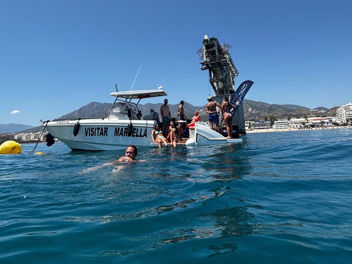The Visitar Marbella dive boat beside the crane structure of The Tower dive site off Marbella